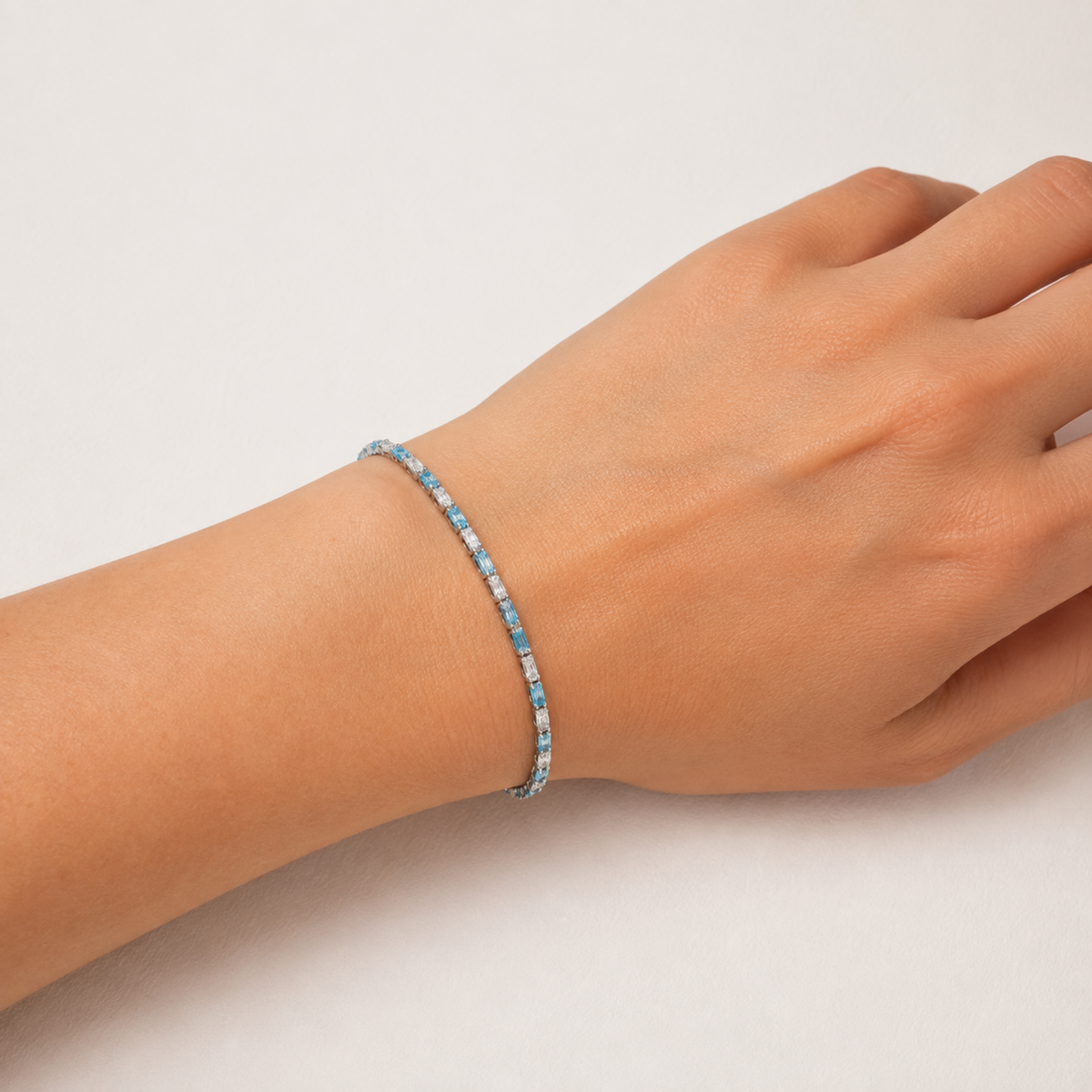 Kadın bileğinde Marevia Silver aqua mavi ve şeffaf baget zirkon taşlı gümüş bileklik
