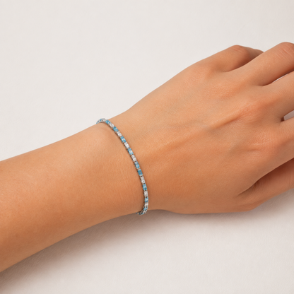 Kadın bileğinde Marevia Silver aqua mavi ve şeffaf baget zirkon taşlı gümüş bileklik
